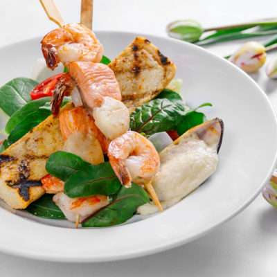 Grilled salad with tiger shrimps, scallops, salmon